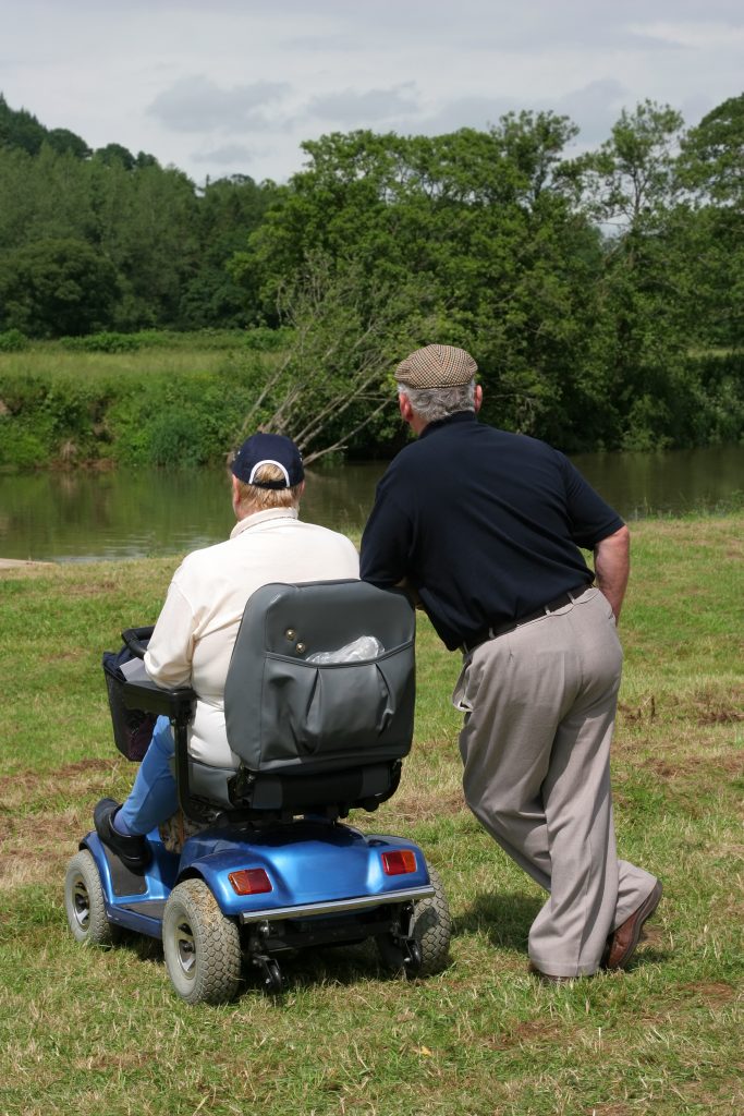 Scooter and two men looking at a river